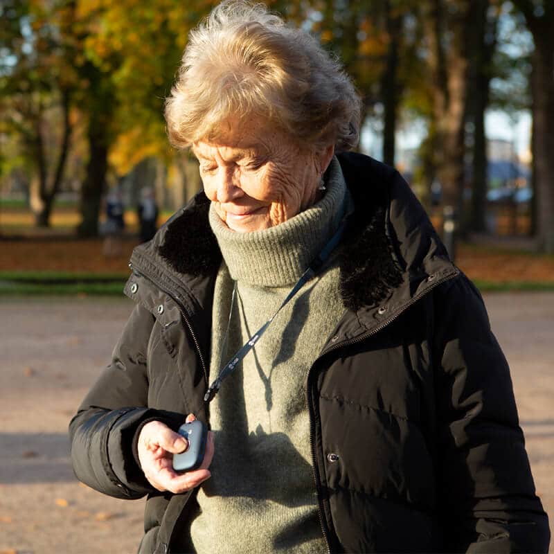 An elderly woman using the pendant