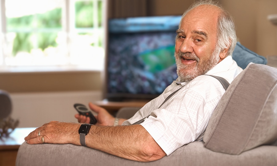 An elderly man wearing the in-home personal alarm