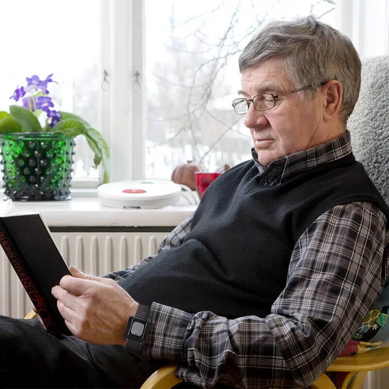 Elderly man wearing the in-home personal alarm