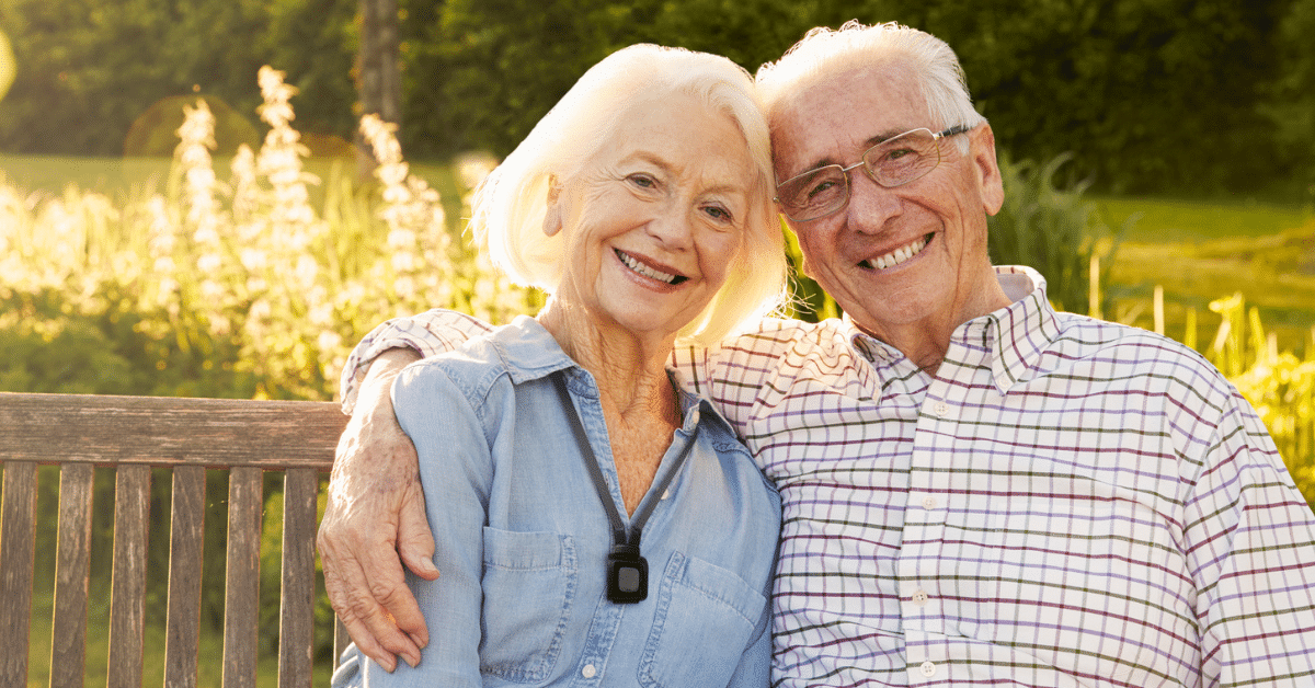 Couple smiling wearing pendant alarm