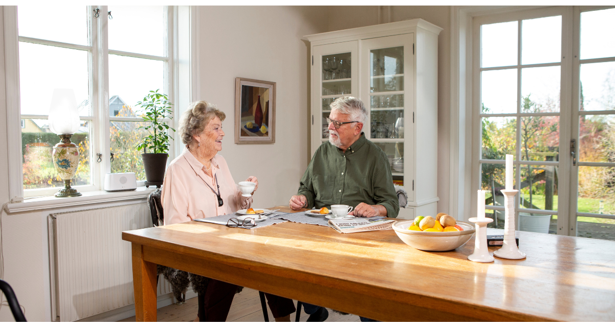 Couple at table with Eliza unit in background