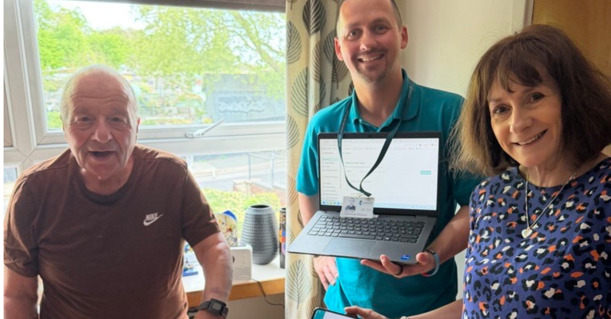 Gary Clark holding a laptop at Westlon Housing Association
